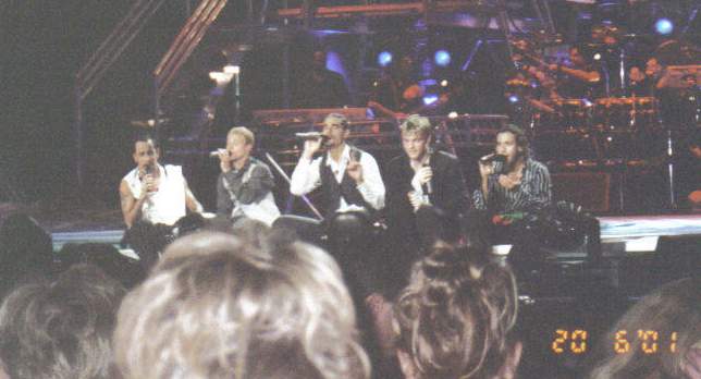 The Boys sitting on stage while singing at a concert in Indianapolis, IN on June 20, 2001.